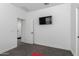 Bedroom with light gray carpet and white walls with a TV mounted on the wall at 12204 W Parkway Ln, Avondale, AZ 85323