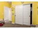 Bedroom with yellow walls, sliding door closet and carpeted floor at 12204 W Parkway Ln, Avondale, AZ 85323