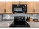 Modern black oven and stove top with gray speckled countertops at 12204 W Parkway Ln, Avondale, AZ 85323