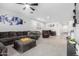 Open-concept living room featuring plush carpeting, a comfortable sectional, and a combined dining area, creating a welcoming atmosphere at 12204 W Parkway Ln, Avondale, AZ 85323