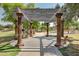 Walkway through shaded arbor with benches, gardens, and playground in the distance at 14864 W Riviera Dr, Surprise, AZ 85379