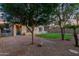 Spacious backyard featuring a lush lawn, brick patio, manicured trees, and a fenced side yard at 14864 W Riviera Dr, Surprise, AZ 85379