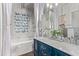 Elegant bathroom with double sinks, marble countertops, floral backsplash and a separate tub and shower at 14864 W Riviera Dr, Surprise, AZ 85379