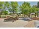 Picnic tables, BBQ grills and green trees around a decorative fountain in a community park at 14864 W Riviera Dr, Surprise, AZ 85379