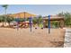 Community playground with swings, slides, and shade structure at 14864 W Riviera Dr, Surprise, AZ 85379