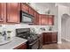 Kitchen featuring cherry cabinets, modern appliances, white countertops, and subway tile backsplash at 14864 W Riviera Dr, Surprise, AZ 85379