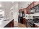 The open kitchen boasts cherry cabinets, white countertops, stainless steel appliances and backsplash at 14864 W Riviera Dr, Surprise, AZ 85379