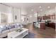 An open floor plan featuring living room with modern sofa and kitchen with cherry cabinets and dining area at 14864 W Riviera Dr, Surprise, AZ 85379