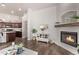 Living room showcasing a fireplace, decorative cabinet, and open floor plan with hardwood flooring and neutral walls at 14864 W Riviera Dr, Surprise, AZ 85379