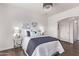 The bright main bedroom features a modern light fixture, a large window, and neutral walls at 14864 W Riviera Dr, Surprise, AZ 85379