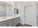 Bathroom featuring double sinks with vanity, large mirror with lighting, and a shower with glass door at 14870 W Encanto Blvd # 2006, Goodyear, AZ 85395