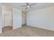 Spacious bedroom featuring neutral carpet, a ceiling fan, and access to the bathroom and walk-in closet at 14870 W Encanto Blvd # 2006, Goodyear, AZ 85395
