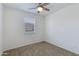 Cozy bedroom featuring a carpeted floor, ceiling fan, and a large window with blinds at 14870 W Encanto Blvd # 2006, Goodyear, AZ 85395