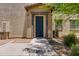 Exterior of a home featuring a covered entryway with dark trim, desert landscaping, and tan stucco at 14870 W Encanto Blvd # 2006, Goodyear, AZ 85395