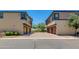 Townhome exterior featuring private garages and a shared brick paved driveway under a clear blue sky at 14870 W Encanto Blvd # 2006, Goodyear, AZ 85395