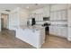 Bright open kitchen features stainless appliances, granite countertops, central island, and white cabinetry at 14870 W Encanto Blvd # 2006, Goodyear, AZ 85395