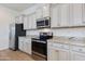 Modern kitchen features stainless steel appliances, granite countertops, and white cabinetry with stylish hardware at 14870 W Encanto Blvd # 2006, Goodyear, AZ 85395