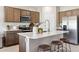 Modern kitchen with stainless steel appliances, wood cabinets, a white countertop island with stools at 1648 S 241St Ave, Buckeye, AZ 85326