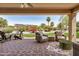 Inviting covered patio with brick pavers, lounge seating, and views of the landscaped backyard at 16972 W Anasazi Ct, Surprise, AZ 85387