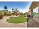Expansive backyard featuring artificial turf, desert landscaping, and a covered patio area at 16972 W Anasazi Ct, Surprise, AZ 85387