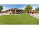 Wide angle of the backyard featuring artificial grass, desert landscaping, and a covered patio at 16972 W Anasazi Ct, Surprise, AZ 85387