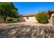 Expansive backyard with gravel landscaping, a covered patio, and desert-friendly plants at 16972 W Anasazi Ct, Surprise, AZ 85387