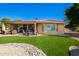 Inviting backyard with artificial turf, stone accents, and a covered patio seating area at 16972 W Anasazi Ct, Surprise, AZ 85387