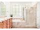 Bright bathroom showcasing a double sink vanity, glass block window, and separate shower at 16972 W Anasazi Ct, Surprise, AZ 85387