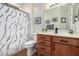 Well-lit bathroom including a sink vanity, toilet, patterned shower curtain and decorative accents at 16972 W Anasazi Ct, Surprise, AZ 85387
