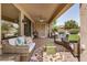 Relaxing covered patio with brick flooring, comfortable seating, and a ceiling fan at 16972 W Anasazi Ct, Surprise, AZ 85387