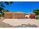 Single-story home with a three-car garage, desert landscaping, and a sunny blue sky above at 16972 W Anasazi Ct, Surprise, AZ 85387