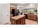 Well-lit kitchen boasts an island, tile countertops, stainless steel refrigerator, and an open layout at 16972 W Anasazi Ct, Surprise, AZ 85387