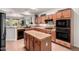 Bright kitchen featuring an island, tile countertops, built-in oven, cooktop, and ample cabinet space at 16972 W Anasazi Ct, Surprise, AZ 85387