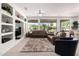Bright living room with carpet, built-in shelves, and backyard views from large windows at 16972 W Anasazi Ct, Surprise, AZ 85387