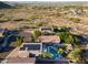Stunning aerial view of the home with a private pool, solar panels, and lush landscaping in a desert setting at 1723 E Pontiac Dr, Phoenix, AZ 85024