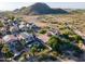 An aerial view of multiple homes with community landscaping, swimming pools and desert mountain views in the background at 1723 E Pontiac Dr, Phoenix, AZ 85024