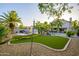 Spacious backyard featuring a green lawn, mature palm trees, a hammock, and a swimming pool at 1723 E Pontiac Dr, Phoenix, AZ 85024
