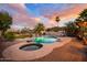 Serene backyard oasis boasting a beautiful pool, integrated spa, and mature palm trees at sunset at 1723 E Pontiac Dr, Phoenix, AZ 85024