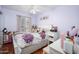 Cozy bedroom featuring hardwood floors and a bed with a floral print comforter and throw pillows at 1723 E Pontiac Dr, Phoenix, AZ 85024