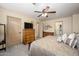 Comfortable bedroom featuring carpeted floors, ceiling fan, dresser and ensuite bathroom at 1723 E Pontiac Dr, Phoenix, AZ 85024