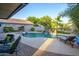 Private backyard oasis featuring a sparkling pool, rock waterfall, and lush tropical landscaping at 1723 E Pontiac Dr, Phoenix, AZ 85024