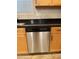 Stainless steel dishwasher, wood cabinets, and black countertops are featured at 1736 W Pollack St, Phoenix, AZ 85041