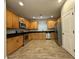 Well-lit kitchen with stainless steel appliances, wood cabinets, dark countertops and tile flooring at 1736 W Pollack St, Phoenix, AZ 85041