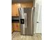 Stainless steel refrigerator alongside maple kitchen cabinets with a door at 1736 W Pollack St, Phoenix, AZ 85041