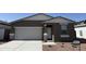 Front exterior of home with two-car garage and gravel landscaping at 18232 W La Senda Dr, Surprise, AZ 85387