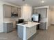 Modern kitchen featuring stainless steel appliances, subway tile backsplash, and island with sink at 18232 W La Senda Dr, Surprise, AZ 85387