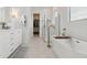 Modern bathroom with a soaking tub, glass-enclosed shower, and a stylish vanity with storage at 20312 W Sells Dr, Buckeye, AZ 85396