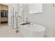 Bright bathroom featuring a modern soaking tub, glass shower, and a spacious walk-in closet at 20312 W Sells Dr, Buckeye, AZ 85396