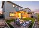 An inviting backyard with a seating area, lush lawn, and a covered patio with string lights for outdoor entertaining at 2067 N Marketside Ave, Buckeye, AZ 85396