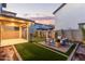 A serene backyard boasting a covered patio, meticulously maintained lawn, and a charming patio seating area at 2067 N Marketside Ave, Buckeye, AZ 85396